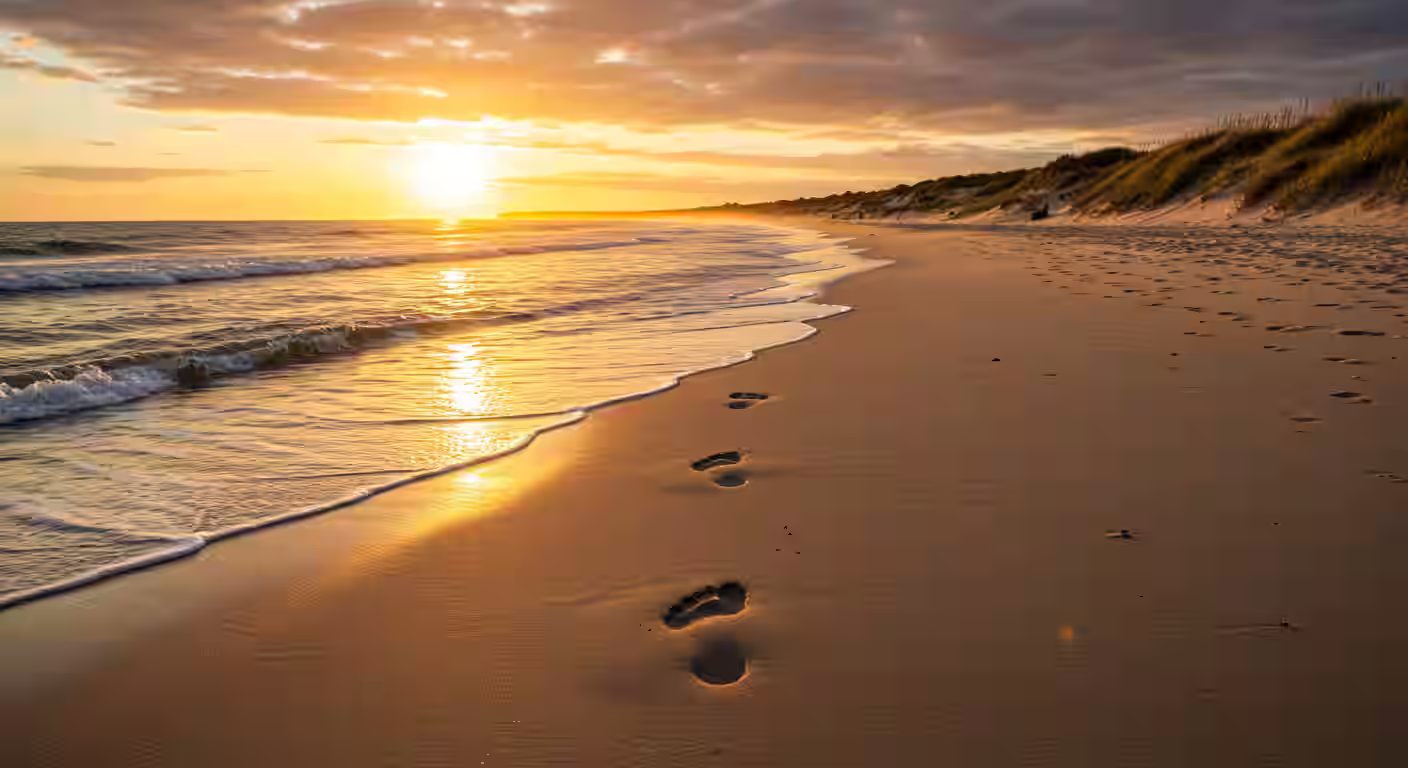 Pegadas na areia da praia com luz dourada simbolizando caminhos conhecidos por Deus